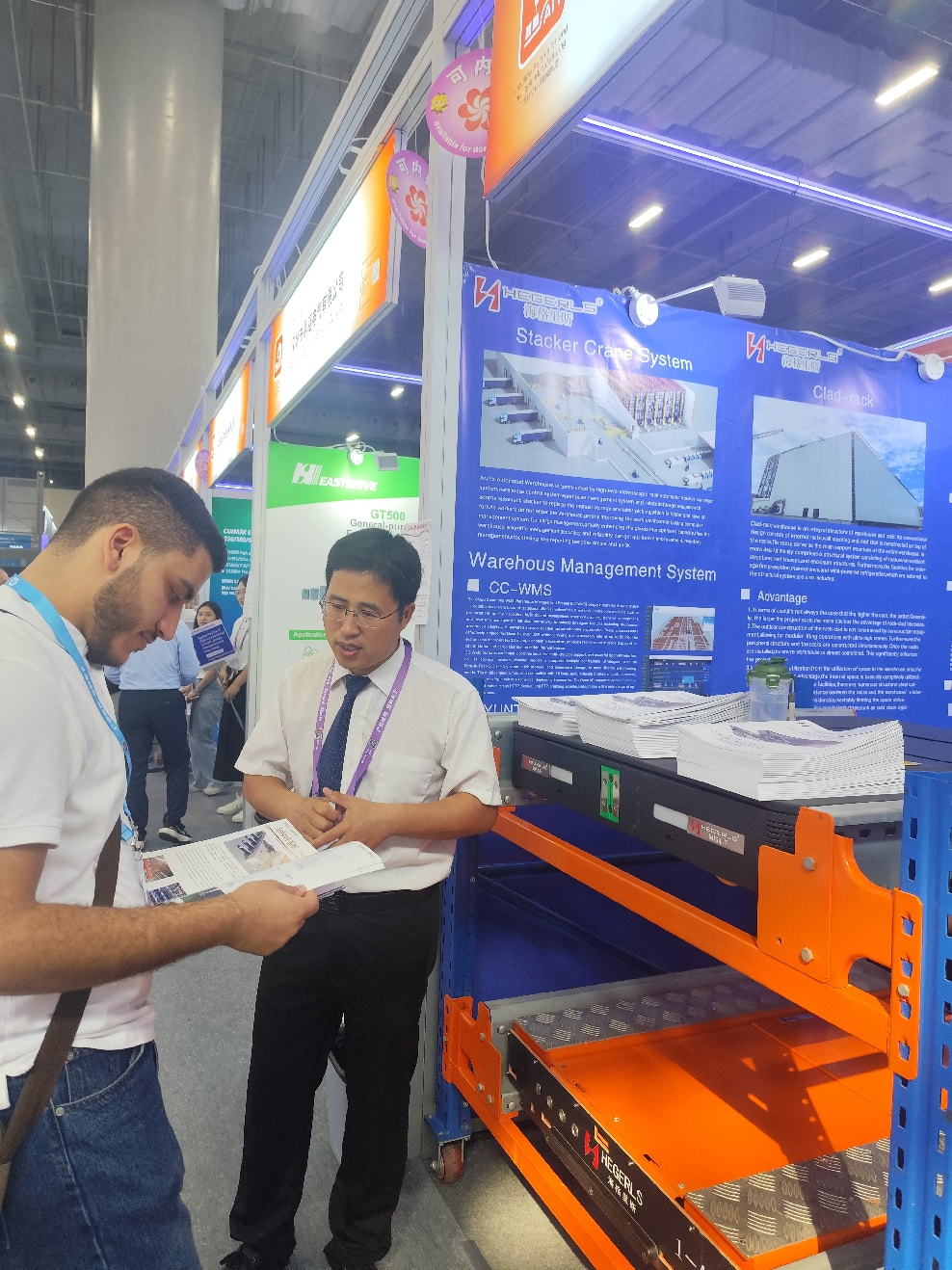 Visitors discussing automated warehouse projects at the HEGERLS booth